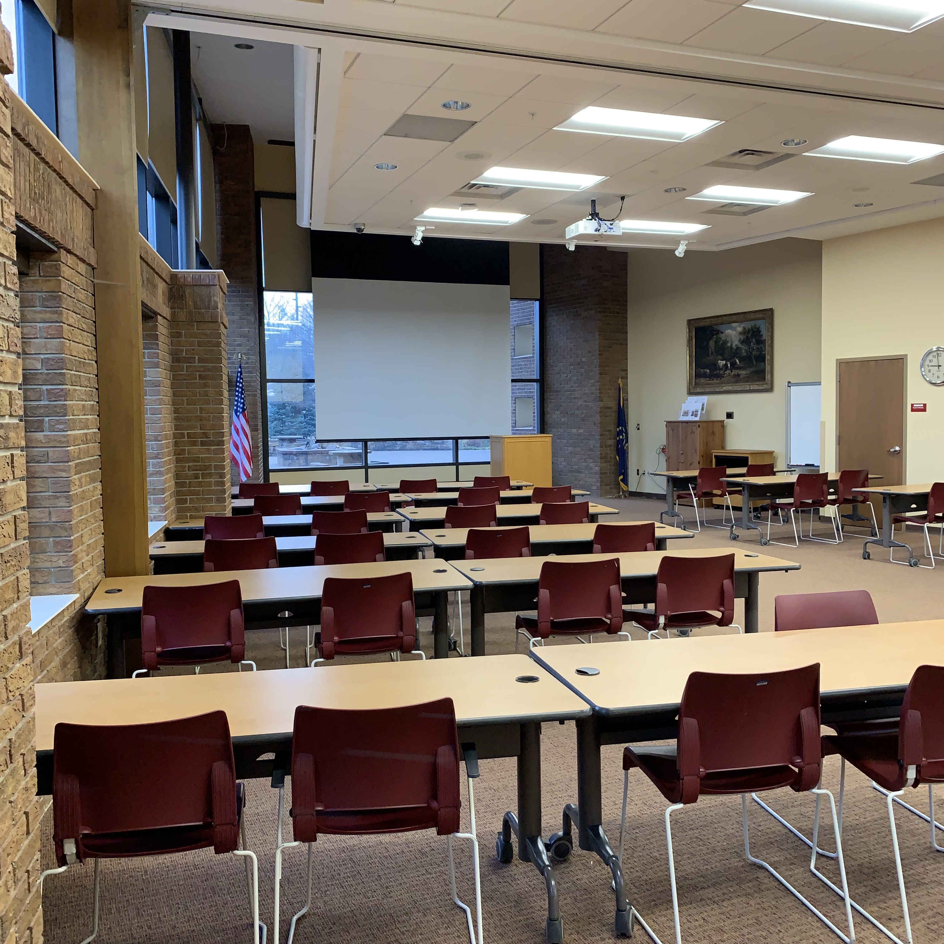 Community Room with tables, chairs, and projector screen.