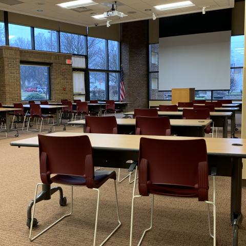 Community Room with tables, chairs, and projector screen.